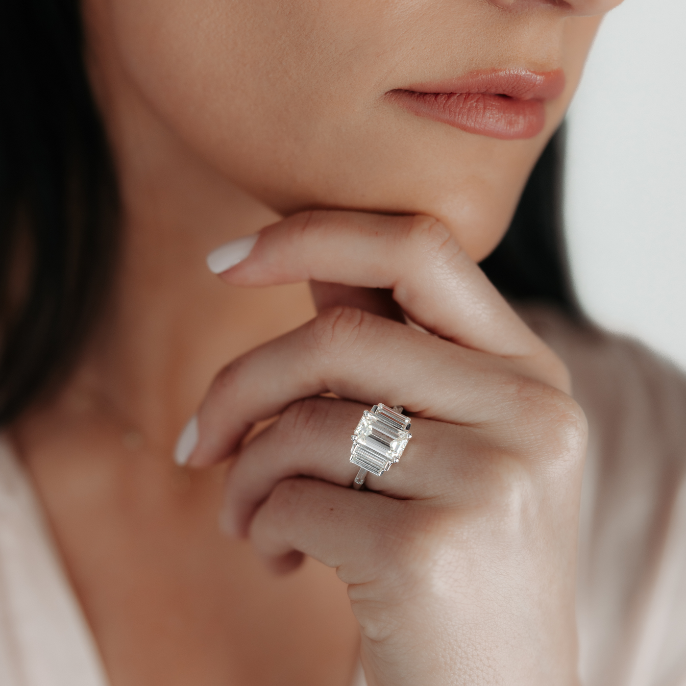 Emerald cut three stone diamond engagement ring