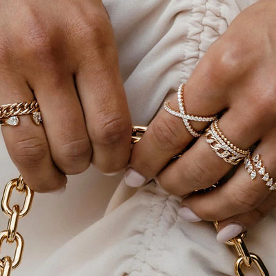 a woman wearing a mix of gold and diamond rings