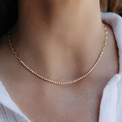 gold necklace with a row of round cut diamonds